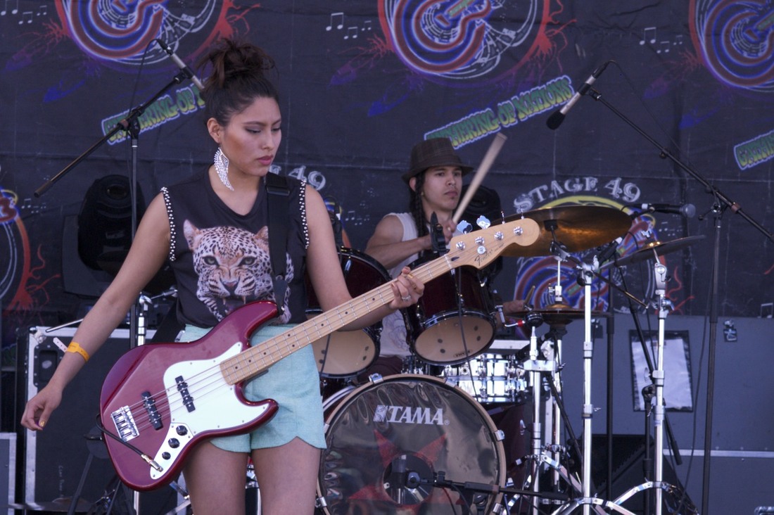 Native American young woman playing bass guitar