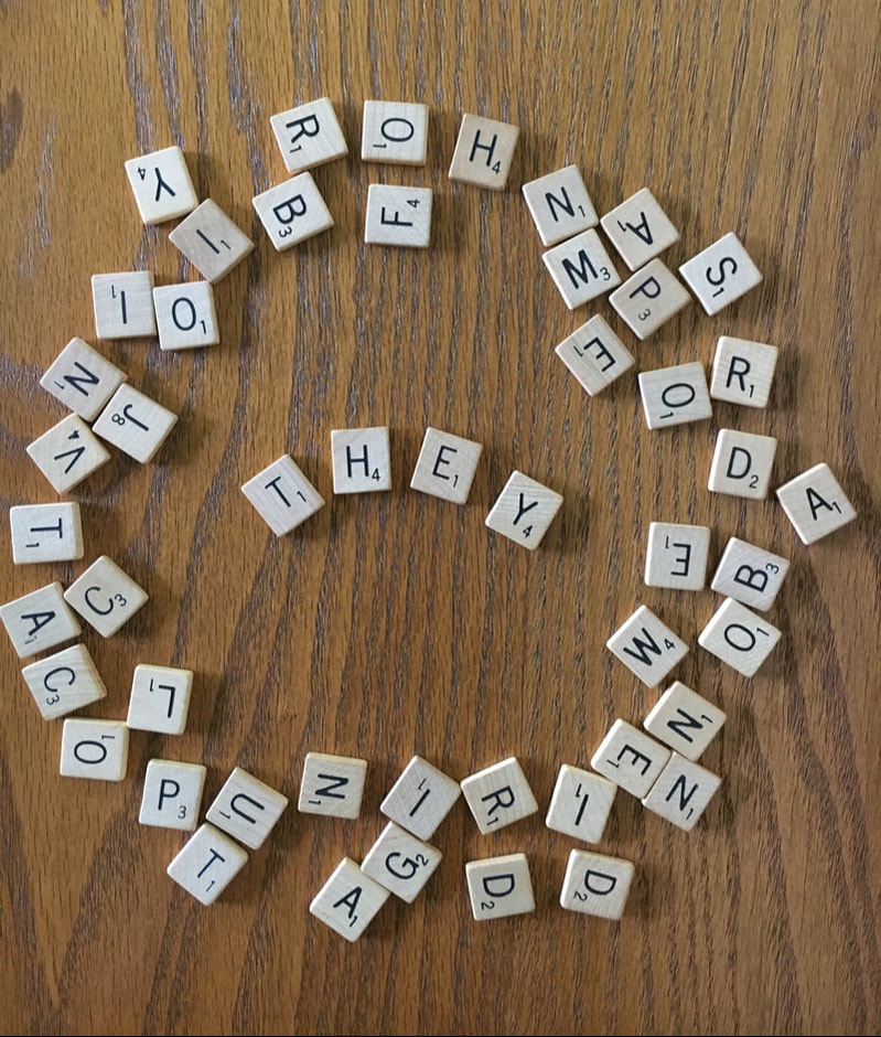 Scrabble tiles surrounding tiles spelling THEY