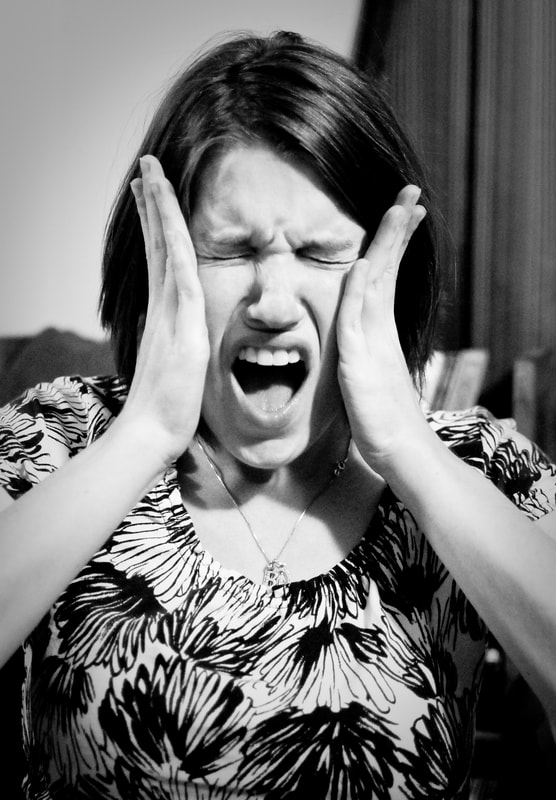 Woman screaming with hands on side of face